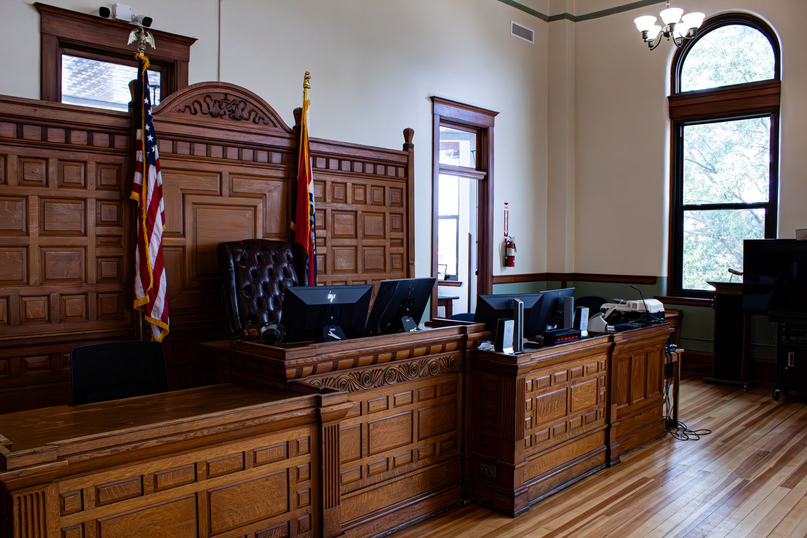 Interior of a U.S. district courthouse — the judge's bench, flags, and witness stand where an appraisal expert testifies