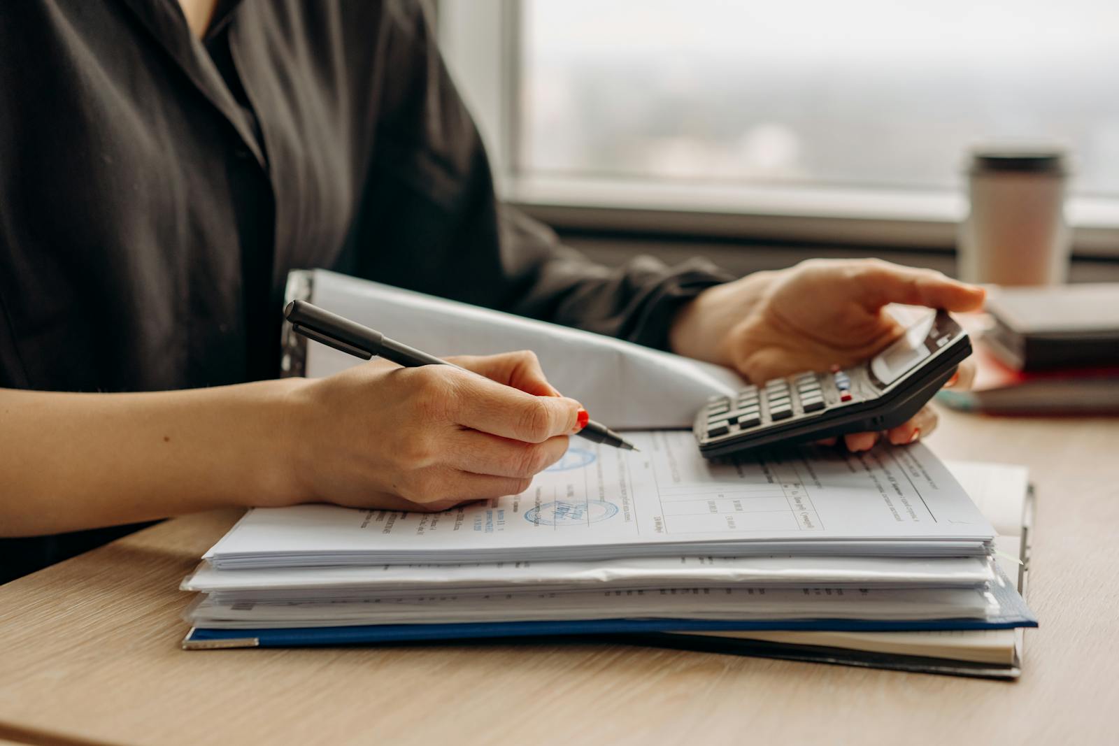 A CPA reviewing estate-tax documents with calculator and signed paperwork at a desk